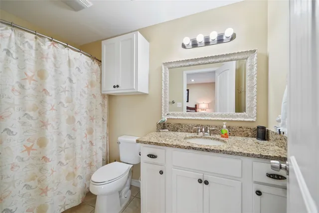 a bathroom with a granite countertop sink mirror and toilet