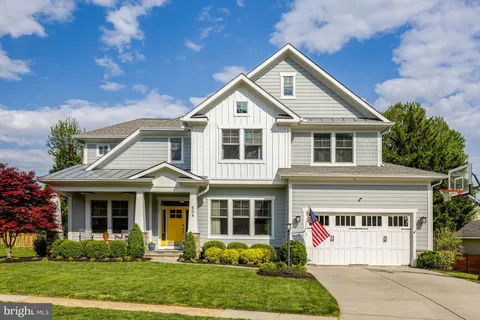 a front view of a house with a yard and potted plants