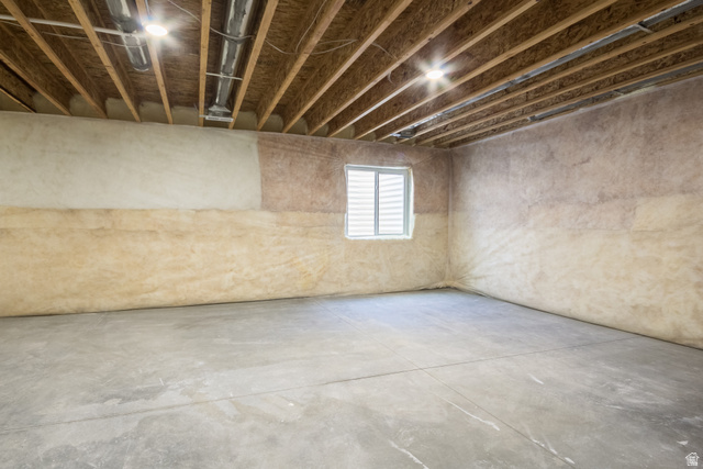 3322 250 S Street Vernal, UT 84078 - Photo 27 of 37 Unfinished basement space featuring exposed wood joists, concrete flooring, and a window with blinds