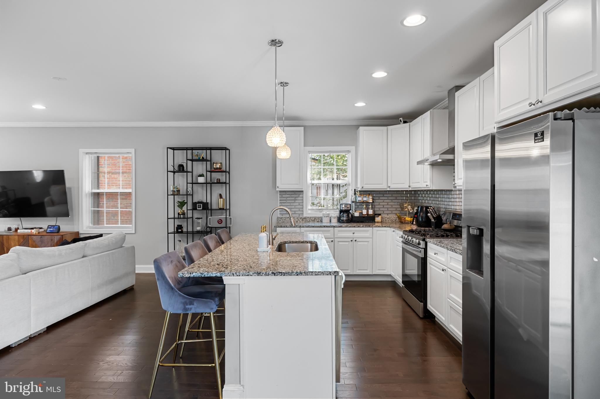 3327 5th Street Southeast Washington, DC 20032 - Photo 11 of 42 a kitchen with a refrigerator a sink dishwasher a stove and a dining table with wooden floor