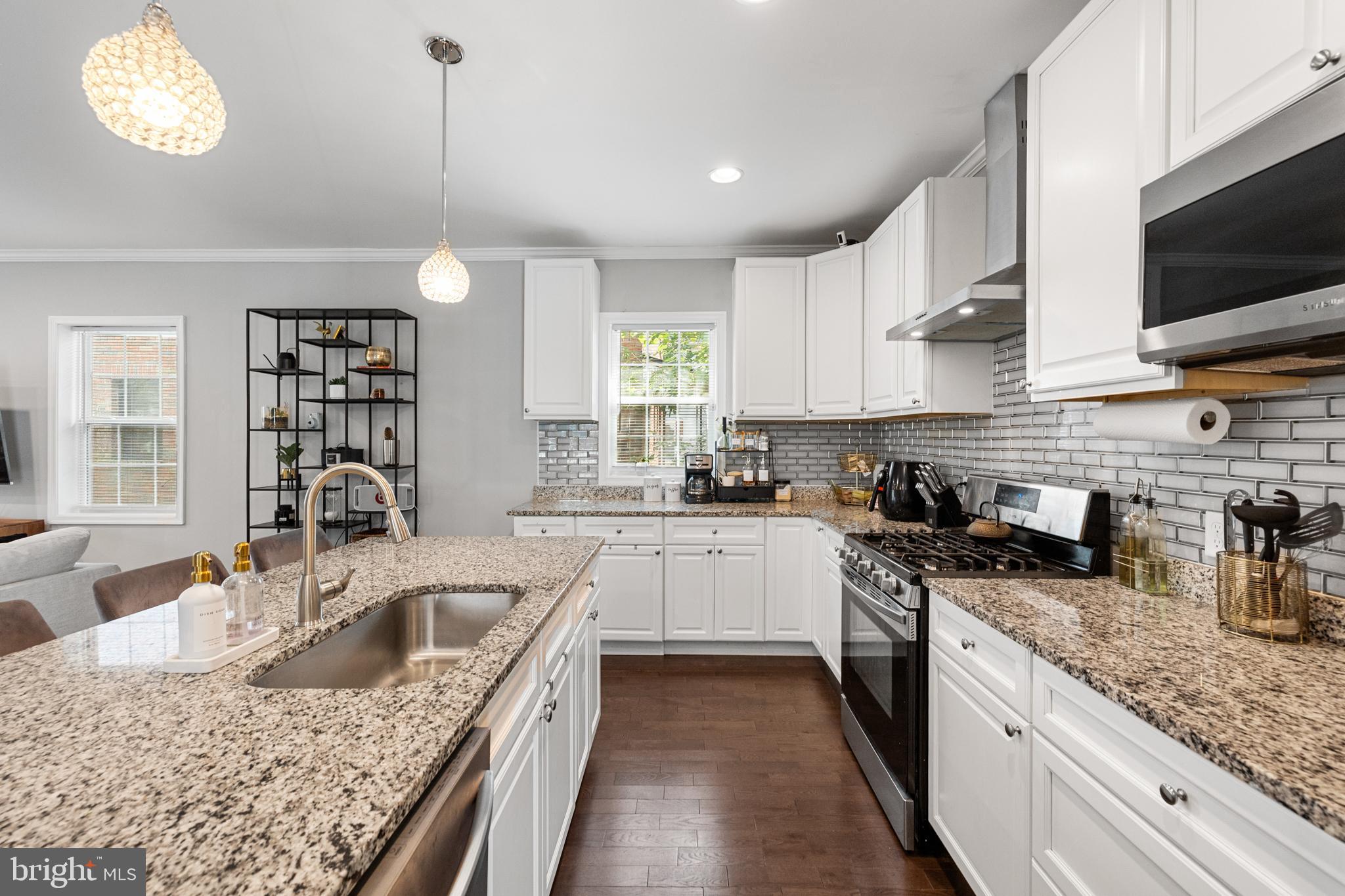 3327 5th Street Southeast Washington, DC 20032 - Photo 13 of 42 a kitchen with stainless steel appliances granite countertop a sink a stove top oven a counter space and cabinets
