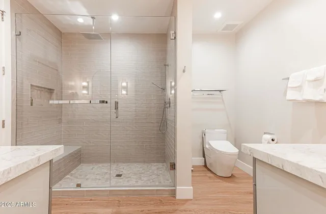 a spacious bathroom with a double vanity sink a mirror and a shower