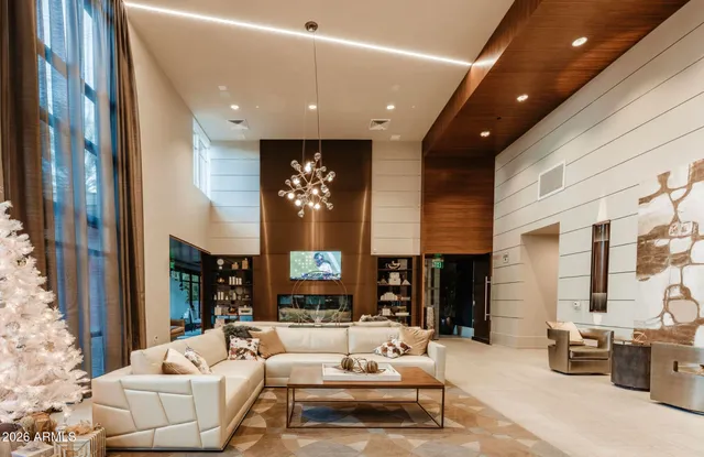 a white house with a large trees covered with wooden fence