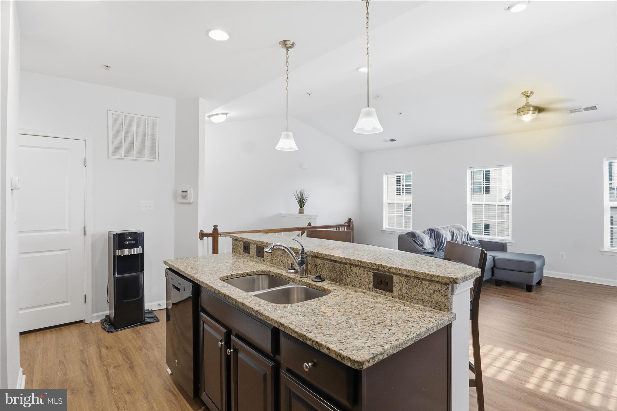7455 Brunson Circle Gainesville, VA 20155 - Photo 18 of 41 a kitchen with a kitchen island a stove a counter space a sink and living room view