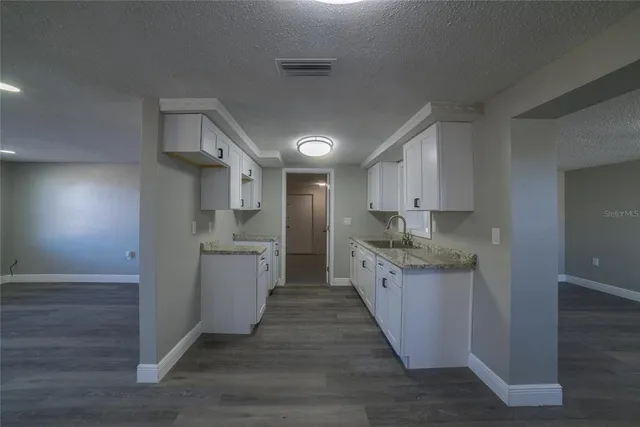 a large kitchen with cabinets and wooden floor