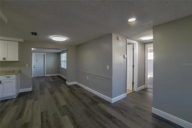 an empty room with wooden floor & bathroom