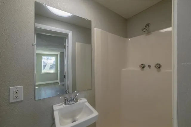 a bathroom with a sink a mirror and a shower