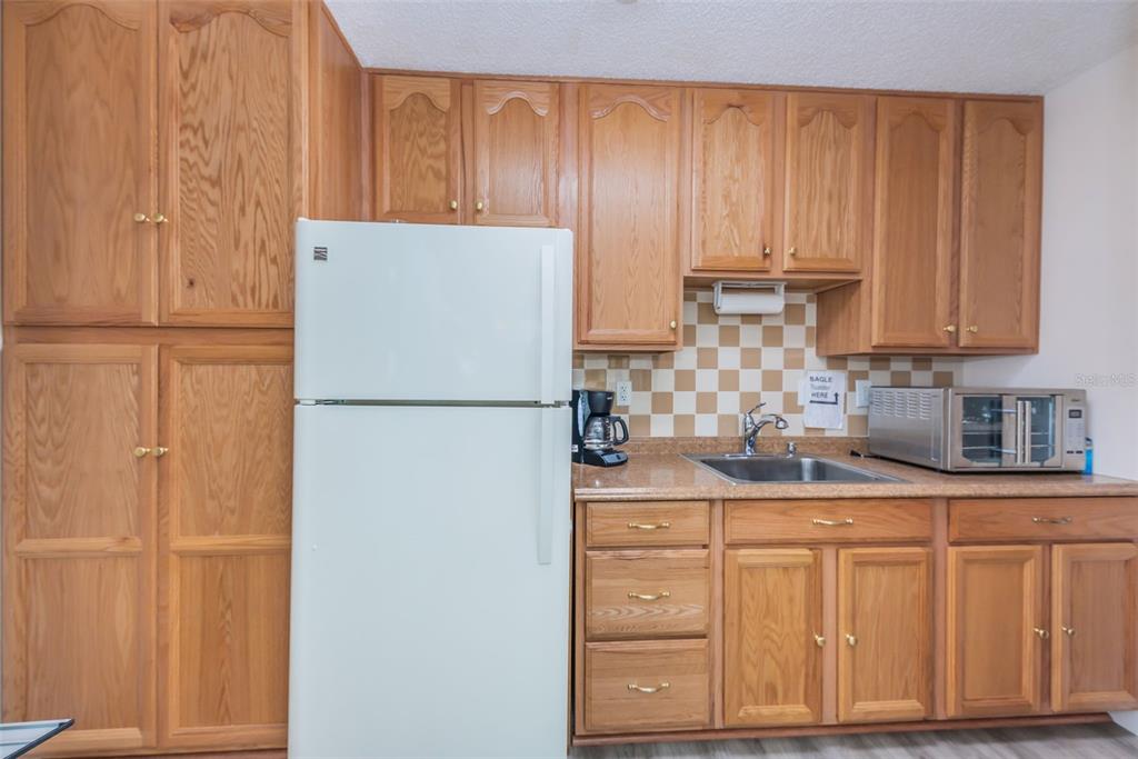 2687 Pine Ridge Way South, Unit B2 Palm Harbor, FL 34684 - Photo 43 of 68 a kitchen with stainless steel appliances granite countertop a refrigerator sink and cabinets