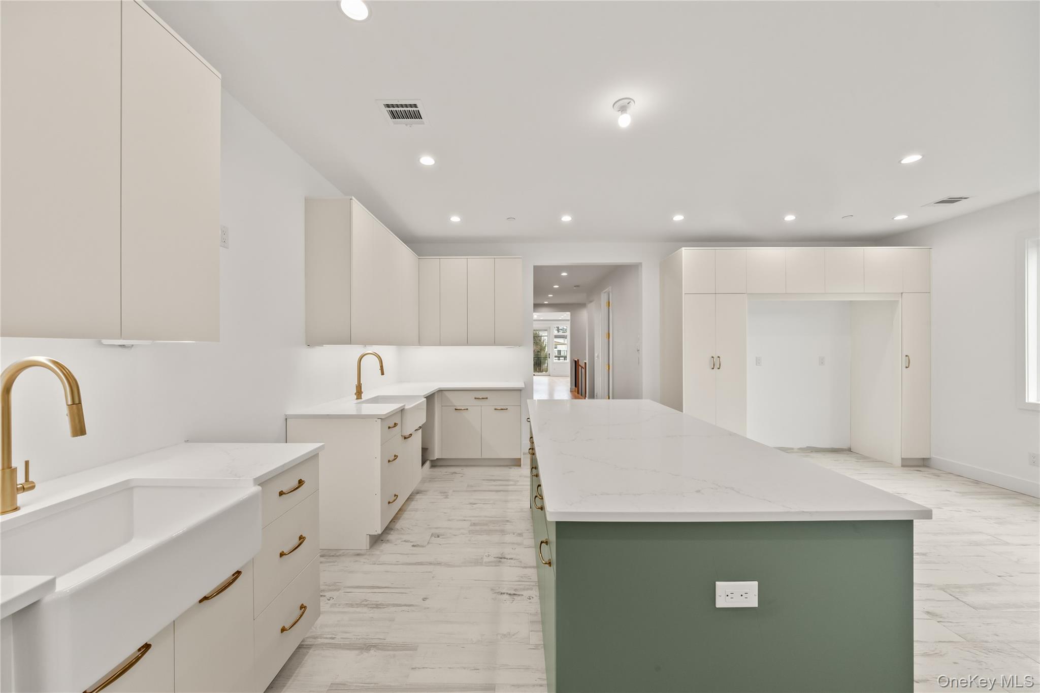 23 Singer Avenue, Unit 211 Spring Valley, NY 10977 - Photo 16 of 45 a large white kitchen with a sink a refrigerator and white cabinets