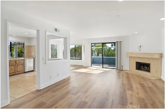 wooden floor fireplace and windows in an empty room