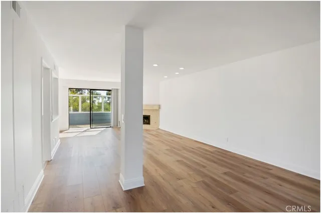 a view of a big room with wooden floor and windows