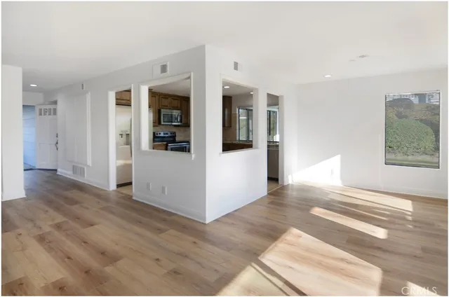 an empty room with wooden floor and fireplace