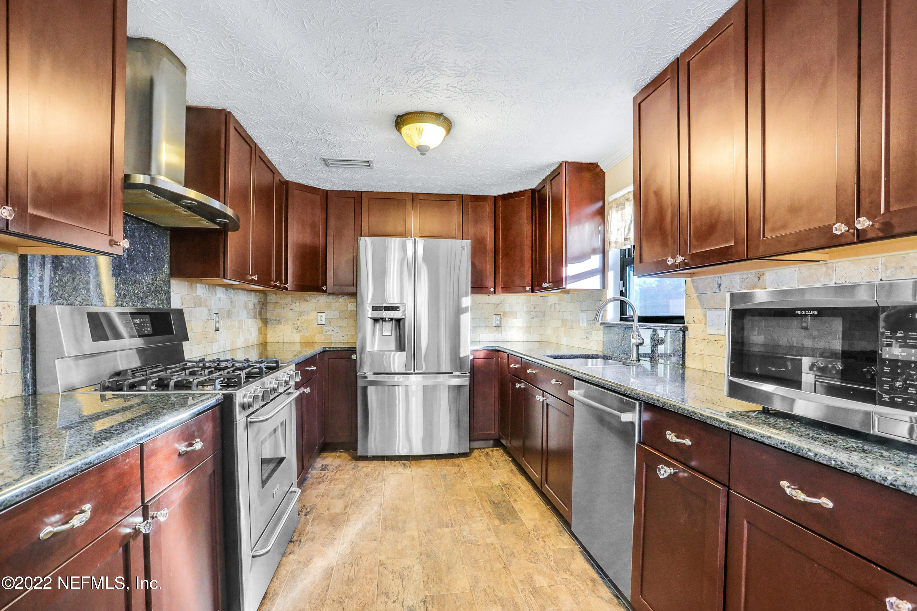2198 Carter Braxton Road Orange Park, FL 32073 - Photo 21 of 33 a kitchen with stainless steel appliances granite countertop wooden cabinets a stove top oven a sink and dishwasher