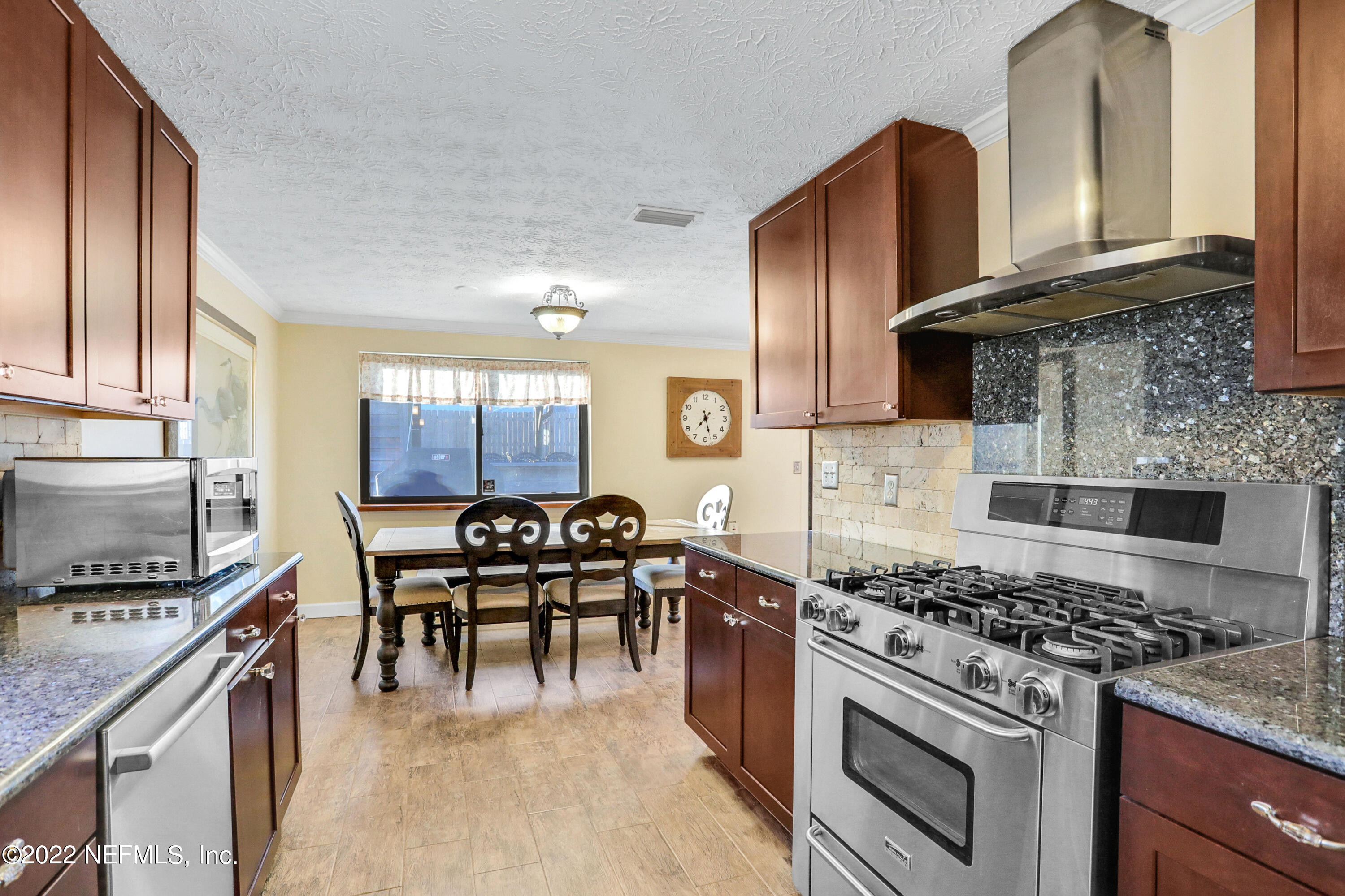 2198 Carter Braxton Road Orange Park, FL 32073 - Photo 23 of 33 a kitchen with stainless steel appliances granite countertop a stove top oven a sink a dining table and chairs