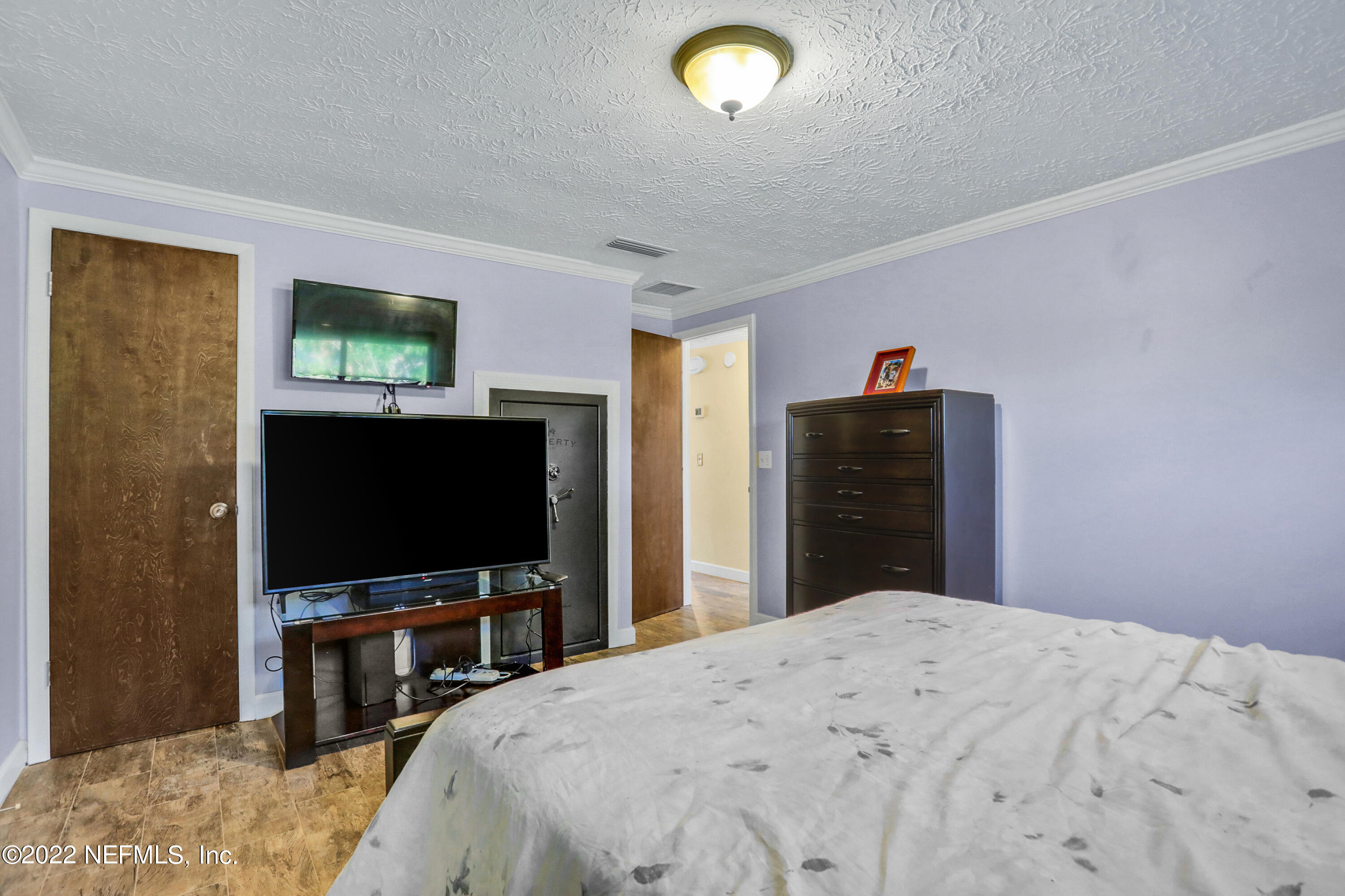 2198 Carter Braxton Road Orange Park, FL 32073 - Photo 30 of 33 a bedroom with a bed and a flat screen tv