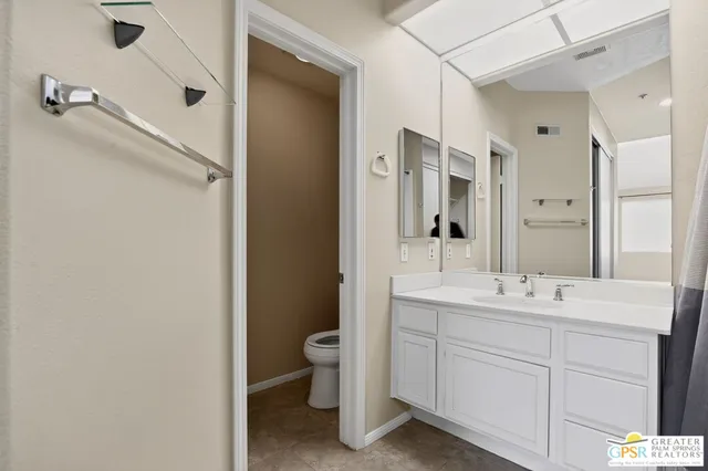 a bathroom with a bathtub shower sink mirror vanity and toilet