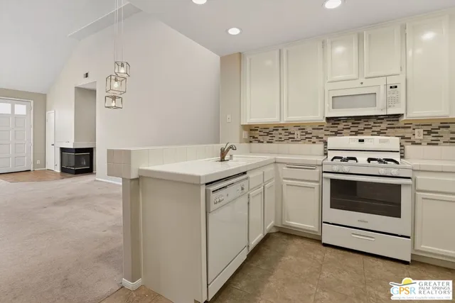 a kitchen with a stove oven and white cabinets