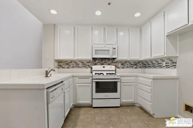 a kitchen with appliances a sink and cabinets