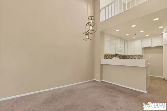 a view of kitchen with white cabinets and stainless steel appliances