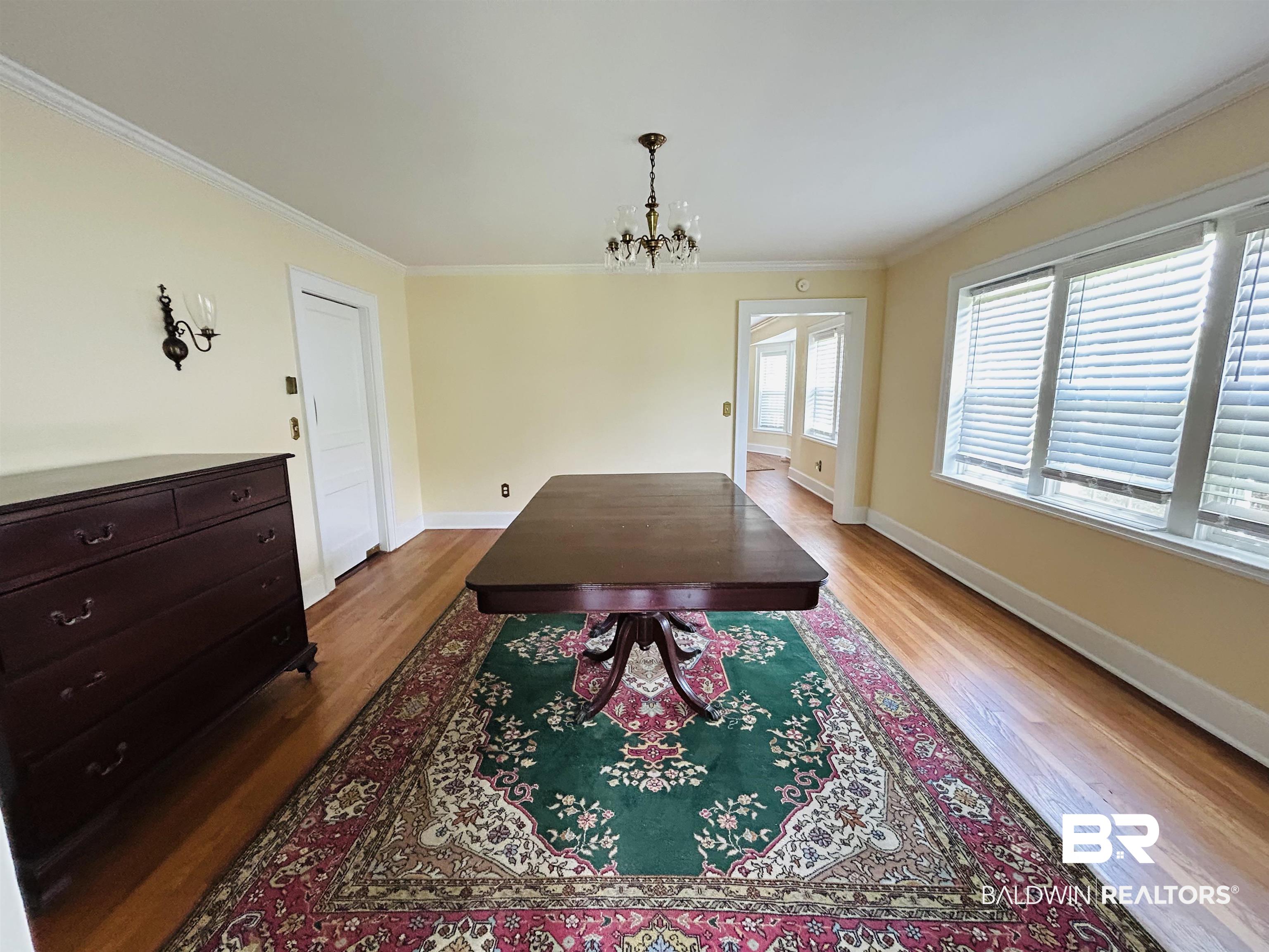 1405 Escambia Avenue Brewton, AL 36426 - Photo 9 of 16 Dining room featuring a chandelier, wood finished floors, and crown molding