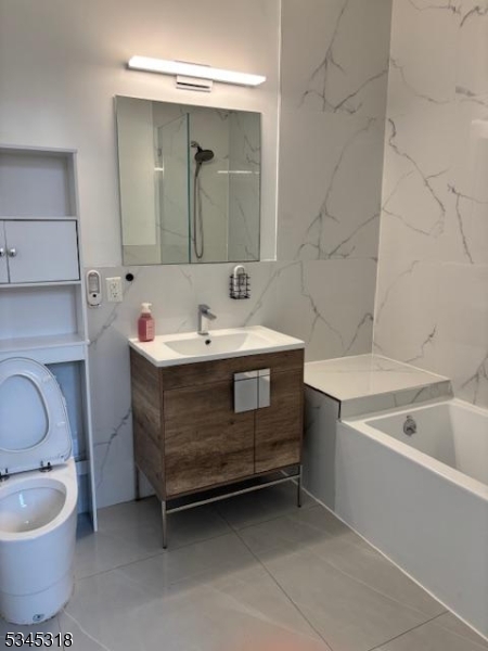 29 Broadway, Unit 2 3 Passaic, NJ 07055 - Photo 2 of 9 a bathroom with a sink toilet and mirror