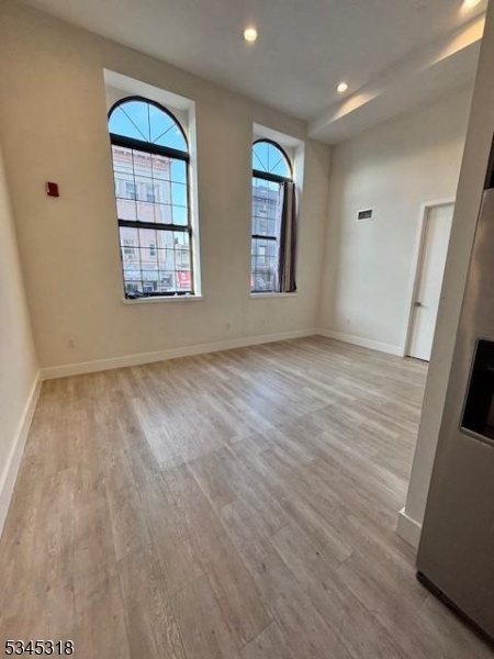 29 Broadway, Unit 2 3 Passaic, NJ 07055 - Photo 6 of 9 wooden floor in an empty room with a window