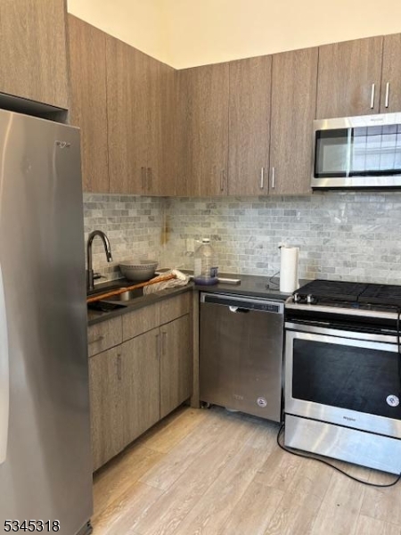 29 Broadway, Unit 2 3 Passaic, NJ 07055 - Photo 9 of 9 a kitchen with stainless steel appliances granite countertop a sink stove and microwave