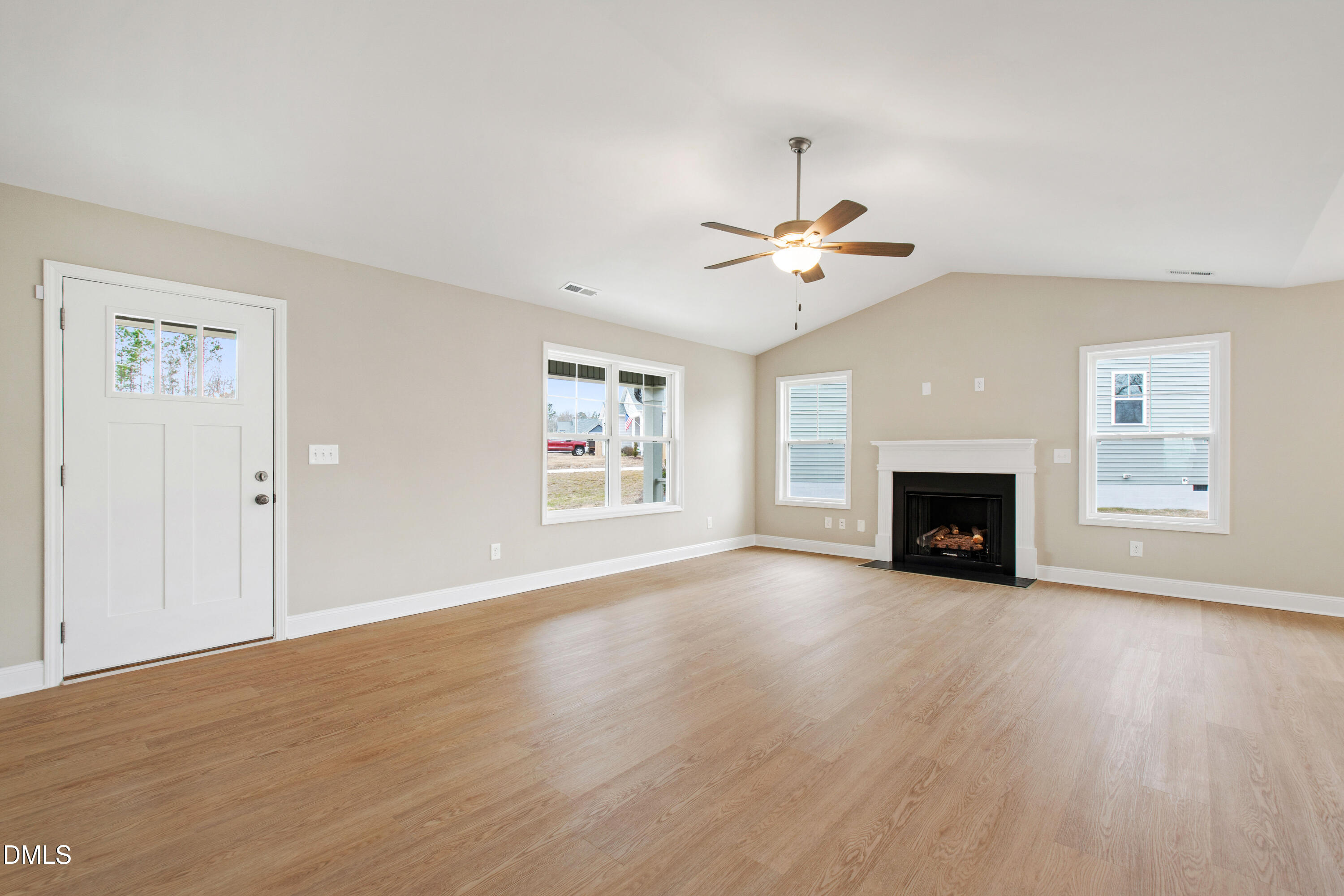 77 Falls Riv Court Broadway, NC 27505 - Photo 3 of 39 an empty room with windows fireplace and a chandelier fan