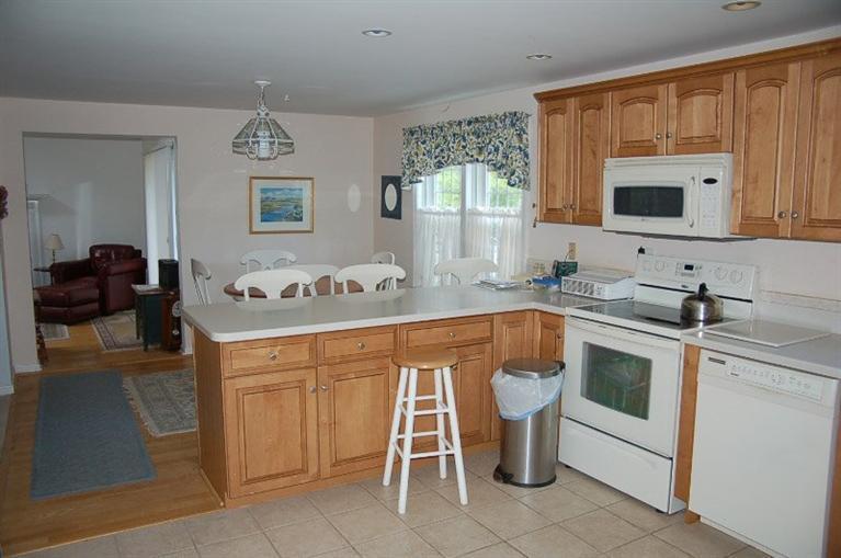 225 Simon Narrows Road Mashpee, MA 02649 - Photo 7 of 22 a kitchen with a sink and cabinets