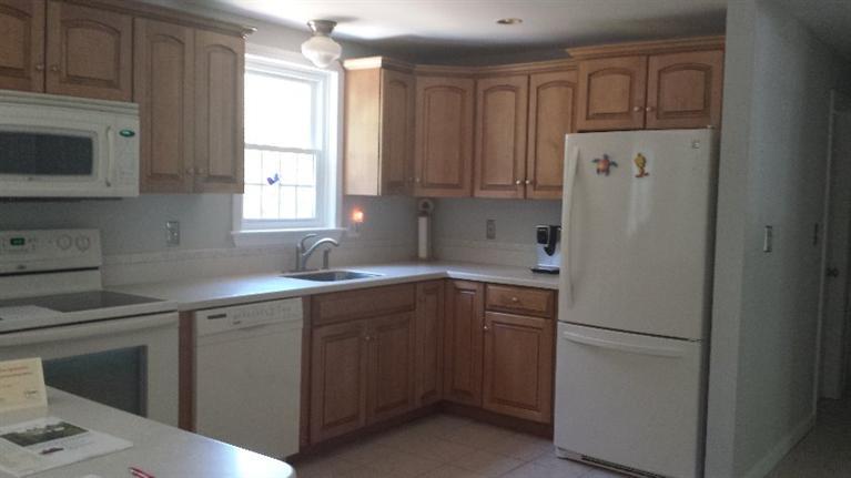 225 Simon Narrows Road Mashpee, MA 02649 - Photo 8 of 22 a kitchen with a sink a refrigerator and cabinets