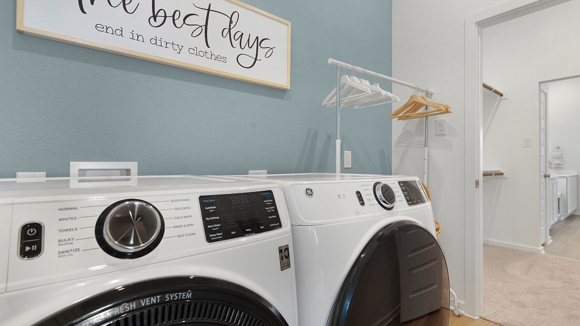 25812 Jasmine Sprig Lane Elgin, TX 78621 - Photo 17 of 33 A well-appointed laundry area features modern appliances and a convenient hanging rack, promoting efficiency in daily routines.