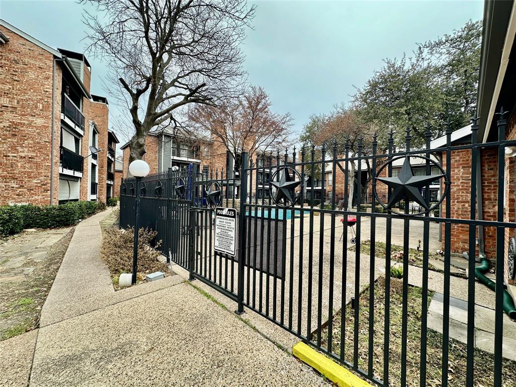 18333 Roehampton Drive, Unit 313 Dallas, TX 75252 - Photo 14 of 19 a view of a street with brick wall and potted plants
