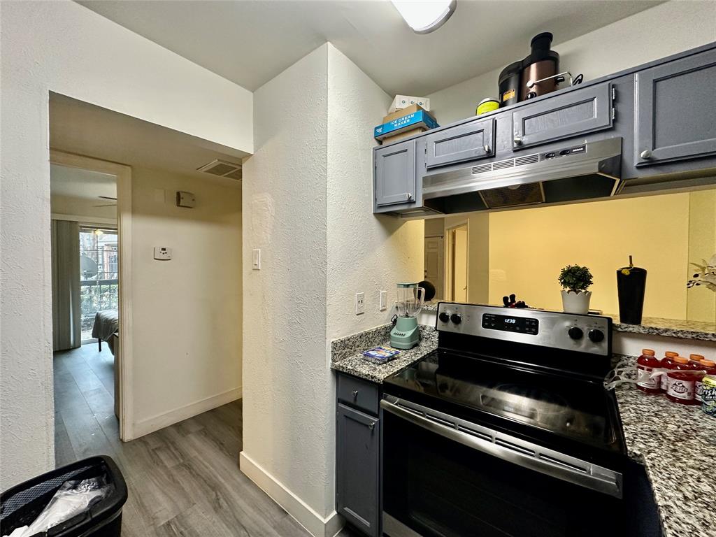 18333 Roehampton Drive, Unit 313 Dallas, TX 75252 - Photo 9 of 19 a kitchen with stainless steel appliances granite countertop a stove and a refrigerator