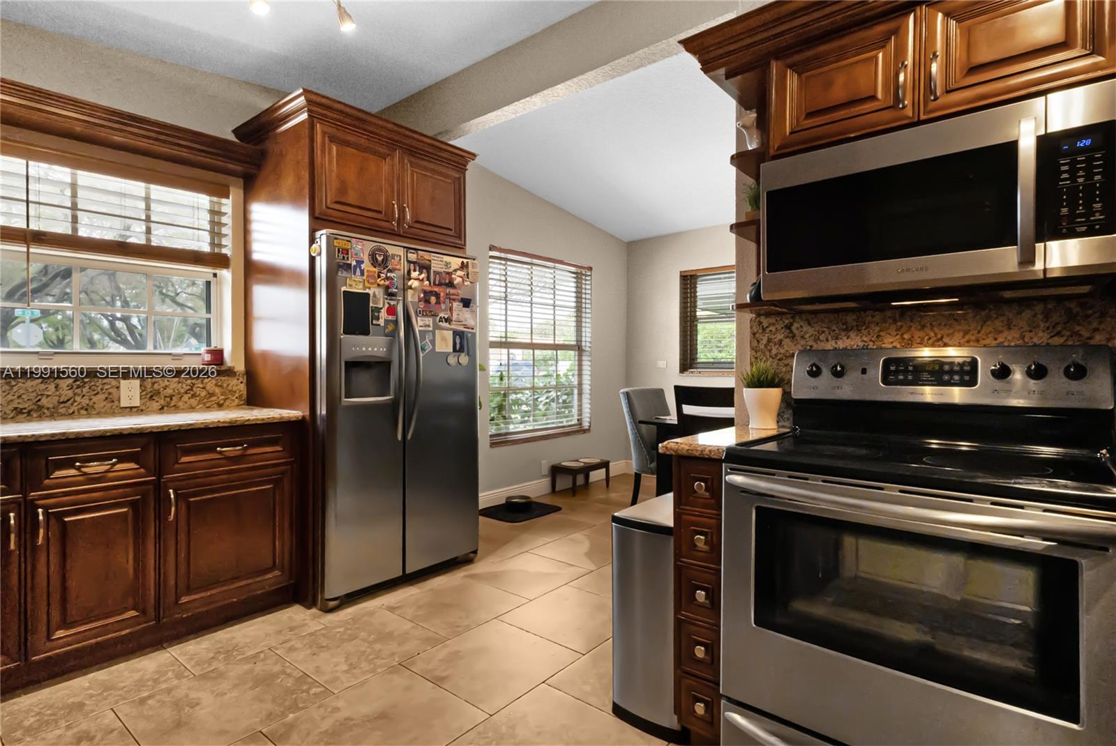 3500 Southwest 13th Street Miami, FL 33145 - Photo 17 of 51 a kitchen with stainless steel appliances granite countertop a stove microwave refrigerator and sink