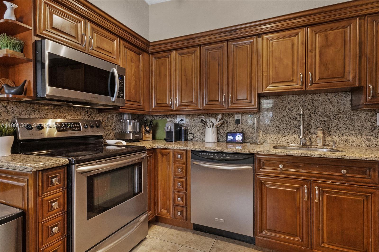3500 Southwest 13th Street Miami, FL 33145 - Photo 19 of 51 a kitchen with stainless steel appliances granite countertop a stove microwave and cabinets