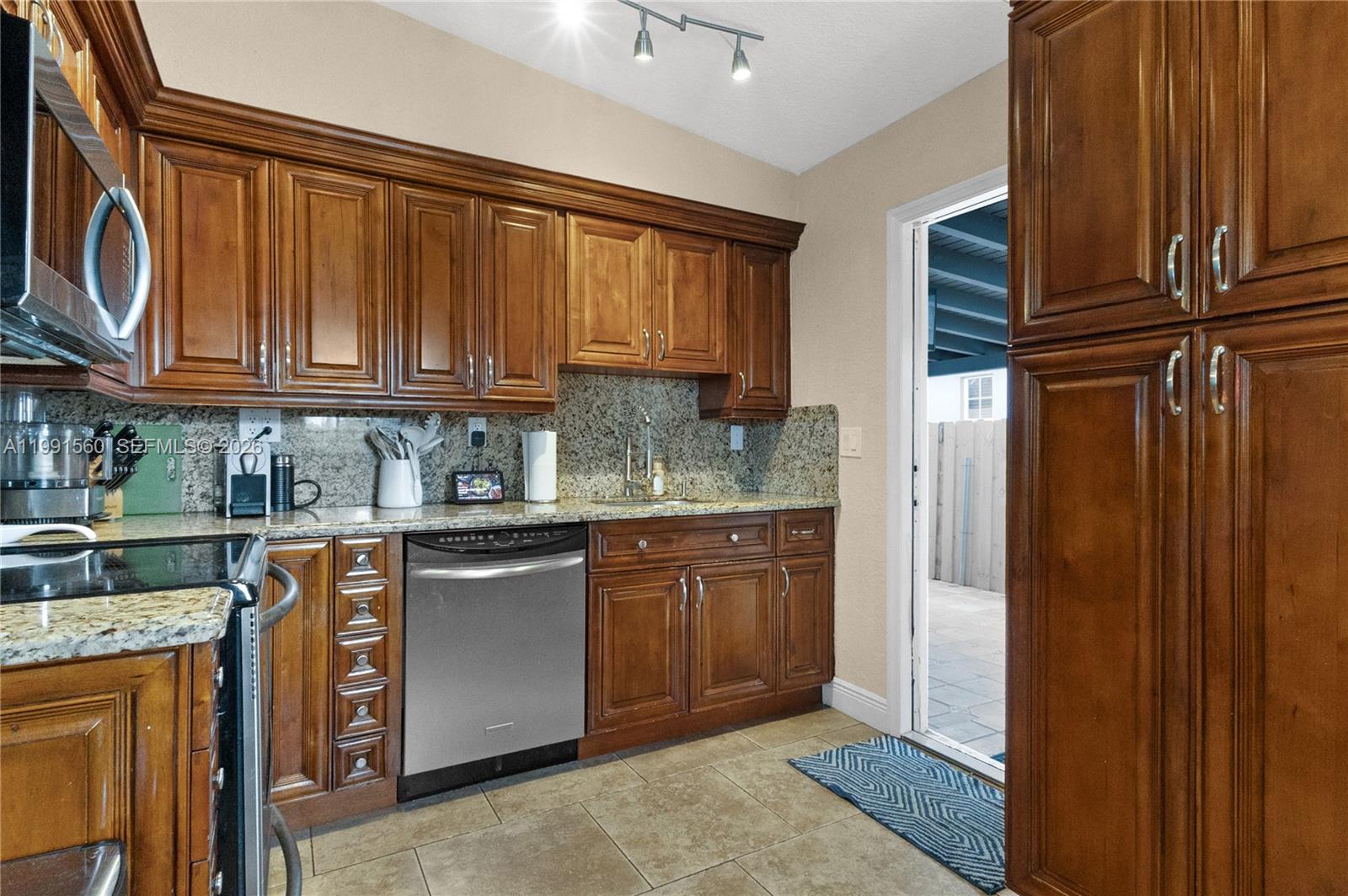 3500 Southwest 13th Street Miami, FL 33145 - Photo 22 of 51 a kitchen with stainless steel appliances granite countertop a refrigerator and wooden cabinets