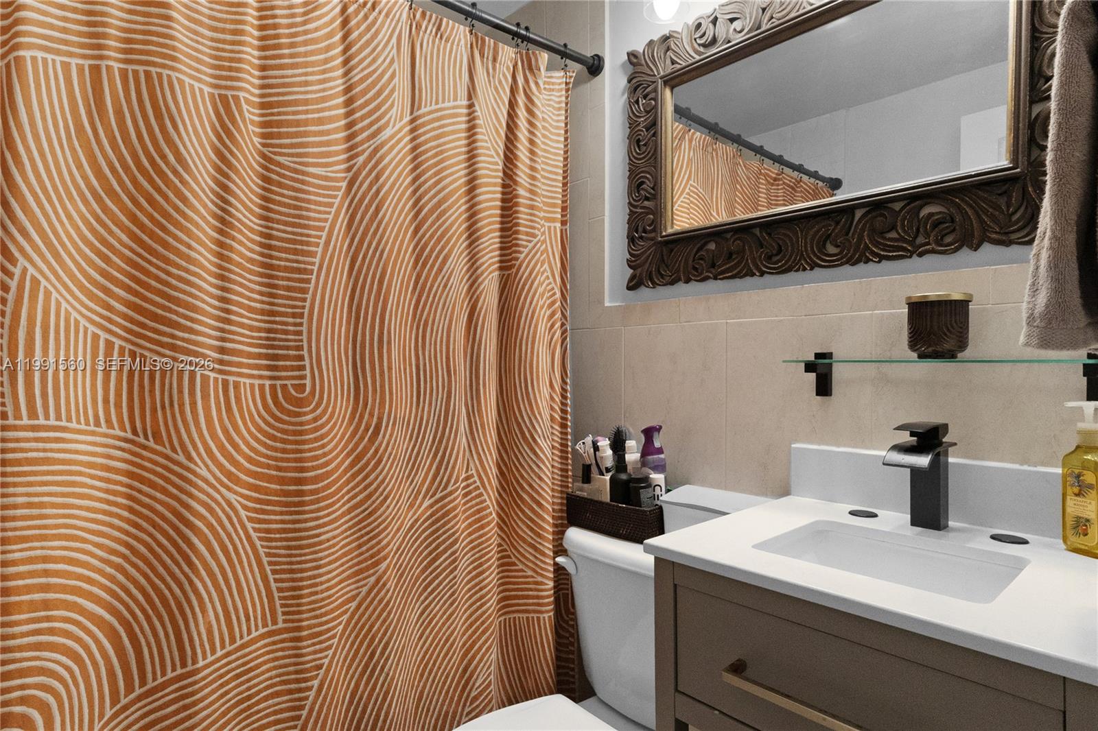 3500 Southwest 13th Street Miami, FL 33145 - Photo 41 of 51 a bathroom with a sink a mirror and shower curtain