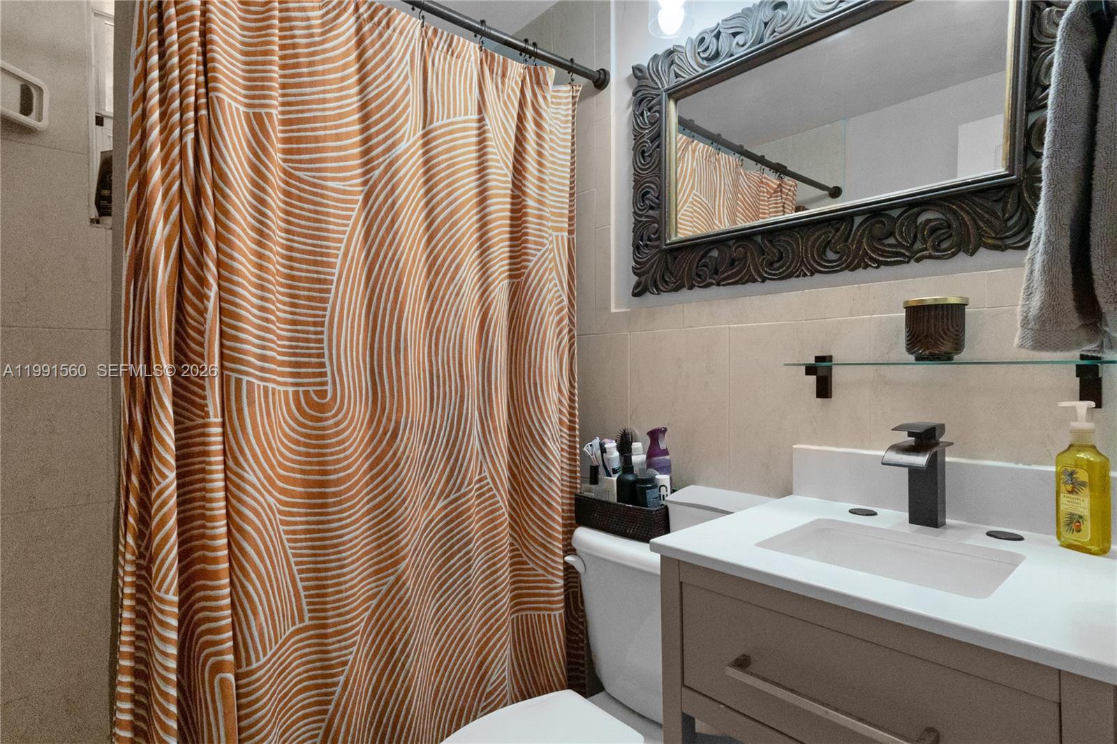 3500 Southwest 13th Street Miami, FL 33145 - Photo 42 of 51 a bathroom with a sink a mirror and shower curtain