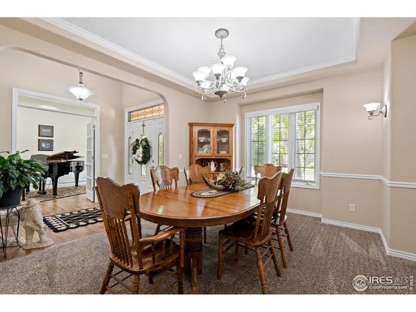 a view of a dining room with furniture a chandelier and wooden floor