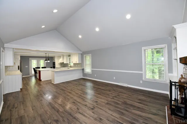 a view of open kitchen with kitchen island wooden floors and center island