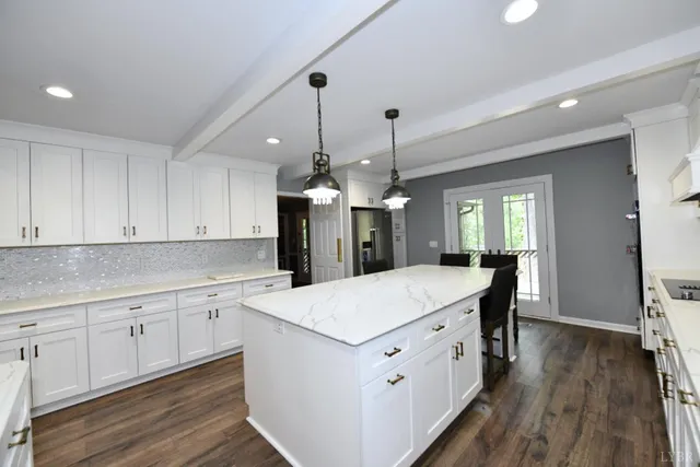 a kitchen with a chandelier and wooden floors