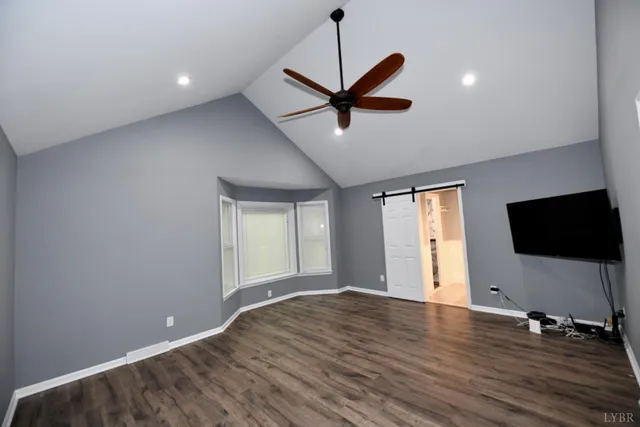 a view of a livingroom with a flat screen tv wooden floor and a ceiling fan