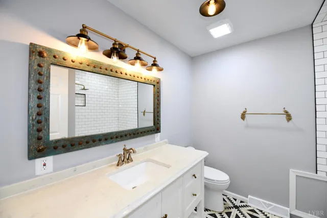 a bathroom with a sink a toilet and mirror