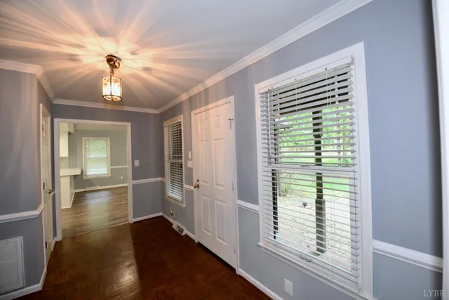 a view of hallway with chandelier and wooden floor