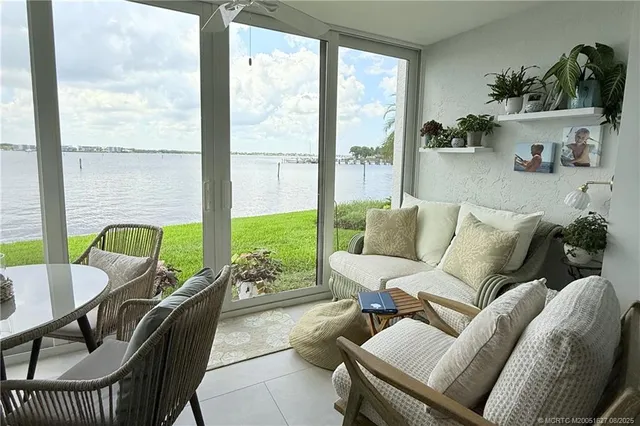 a dining room with furniture and a floor to ceiling window
