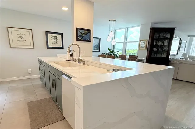 a large kitchen with kitchen island a sink a stove a dining table and chairs