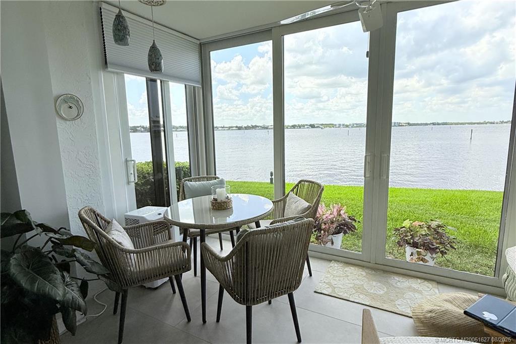 1950 Southwest Palm City Road, Unit 14101 Stuart, FL 34994 - Photo 21 of 36 a dining room with furniture and a floor to ceiling window