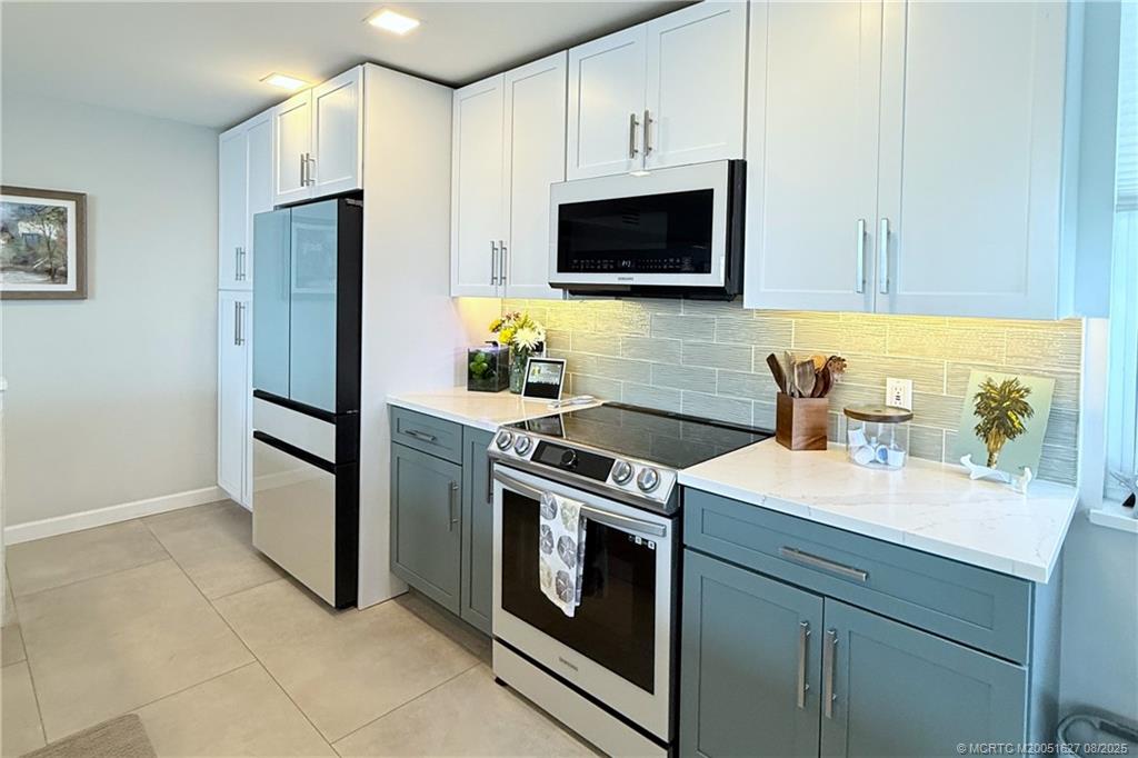 1950 Southwest Palm City Road, Unit 14101 Stuart, FL 34994 - Photo 5 of 36 a kitchen with stainless steel appliances granite countertop a refrigerator stove and sink