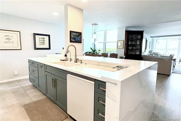 a kitchen with kitchen island granite countertop a sink and cabinets