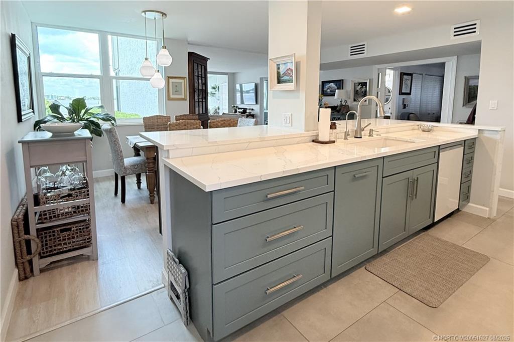 1950 Southwest Palm City Road, Unit 14101 Stuart, FL 34994 - Photo 9 of 36 a kitchen with kitchen island granite countertop a sink and cabinets